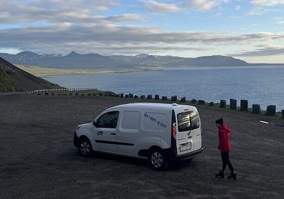Me outside the campervan at a pitstop overlook with ocean views.