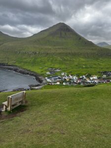 On the Gjogv trail hike near a wooden bench that overlooks the little Gjogv village.