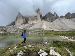 Hiking Tre Cime di Lavaredo hike in the Dolomites with mist covering the mountain peaks.
