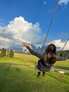 On a swing in Alpe di Siusi with amazing mountain views.