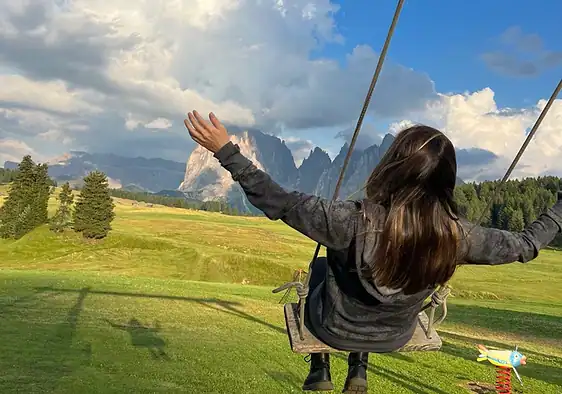 On a swing in Alpe di Siusi, Dolomites