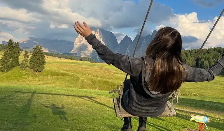 On a swing in Alpe di Siusi, Dolomites